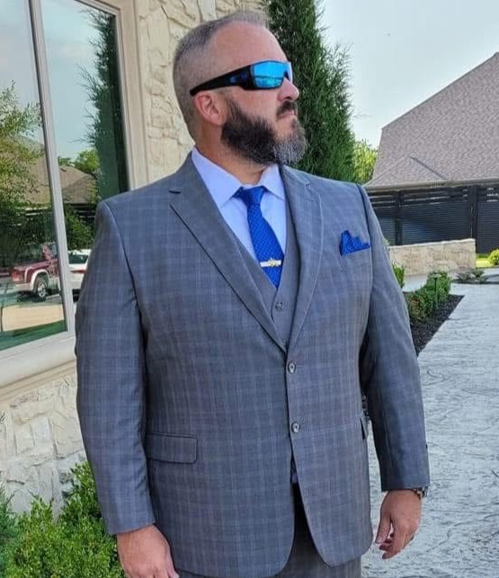 Major Jaime McGuckin in a gray suit and blue tie